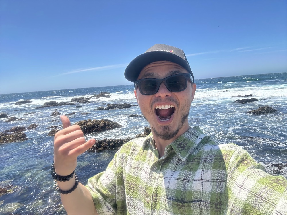 Max laughing on the rocky Pacific coast